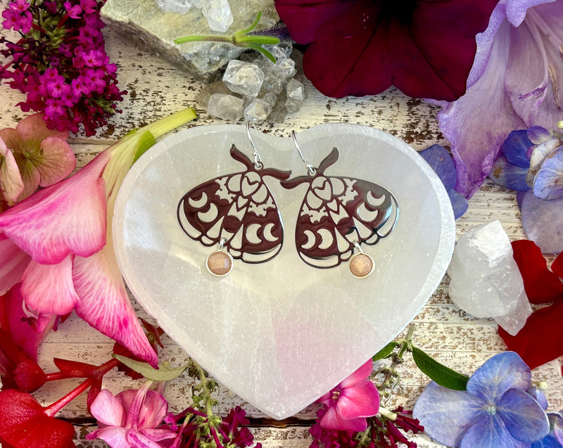 moth earrings with moon phases in heart tray.