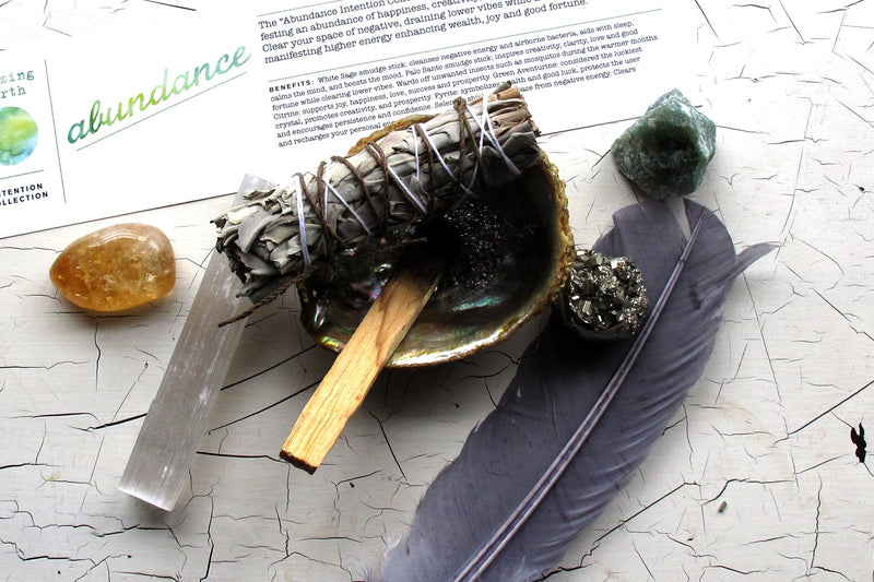 Abundance intention collection shell crystals feather smudge stick shot overhead