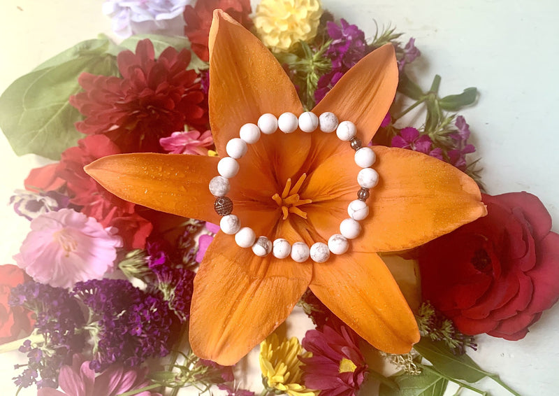 one white howlite crystal bracelet sitting on an orange flower