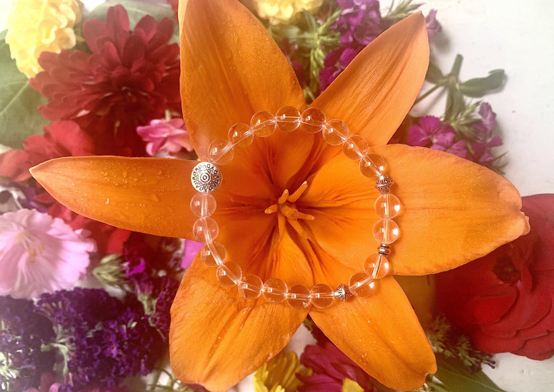 clear quartz beads on an orange flower