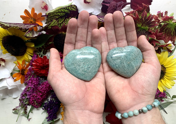two hands holding two green hearts about 2 inches each