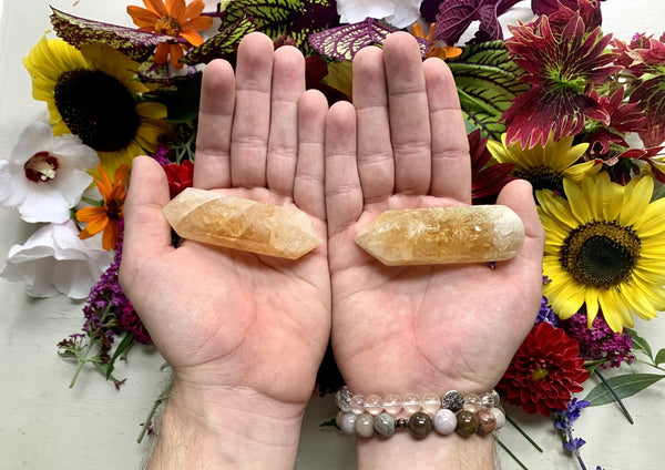 two palms holding yellow sparkly double terminated citrine points 