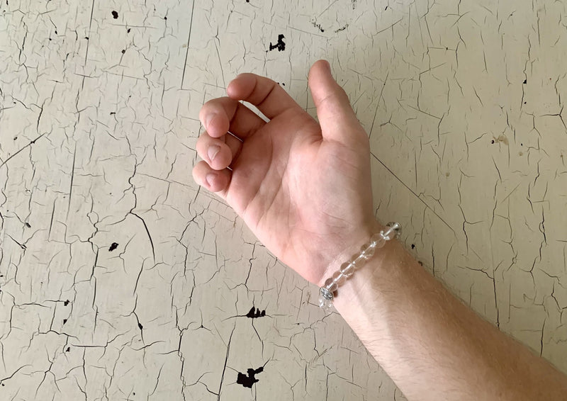 clear quartz beaded bracelet on male wrist.