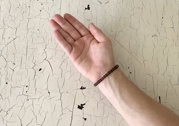 light brown smokey quartz bracelet on male wrist. 