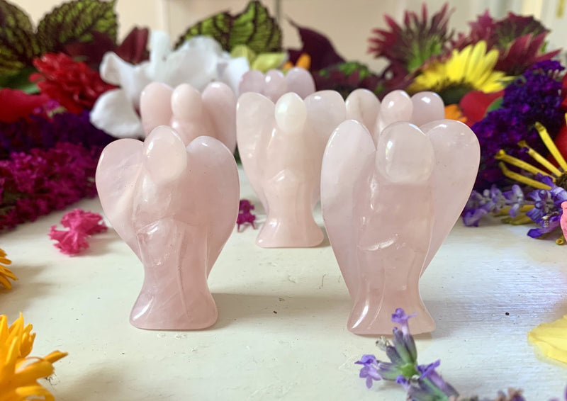 small pink rose quartz angels standing on a tabletop