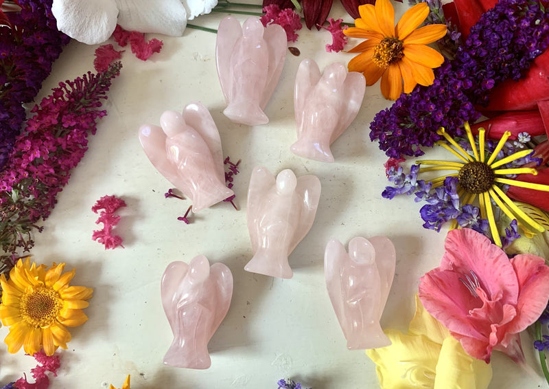 several small pink rose quartz angels laying on tabletop