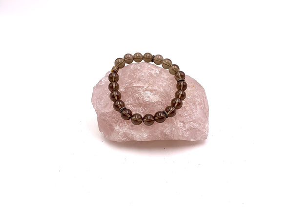 large brown smokey quartz beads on pink rose quartz cluster.
