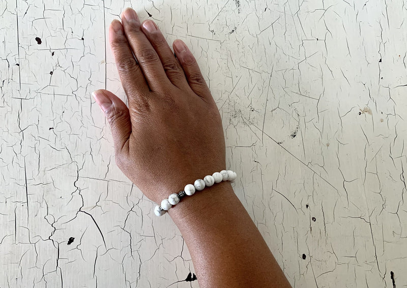 matte white howlite crystal bracelet with black running through crystals on female writst.