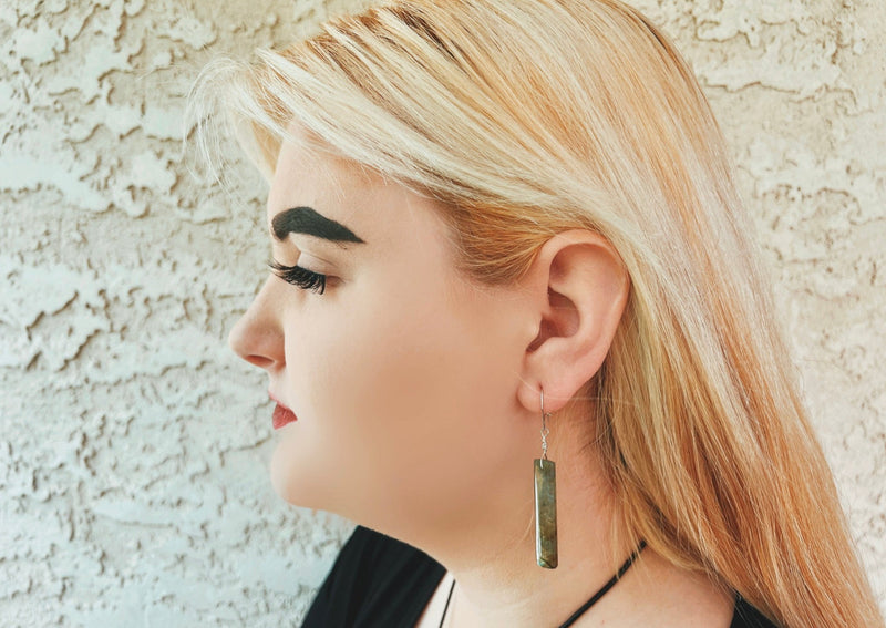 rectangular labradorite earrings hanging on model's ear. 
