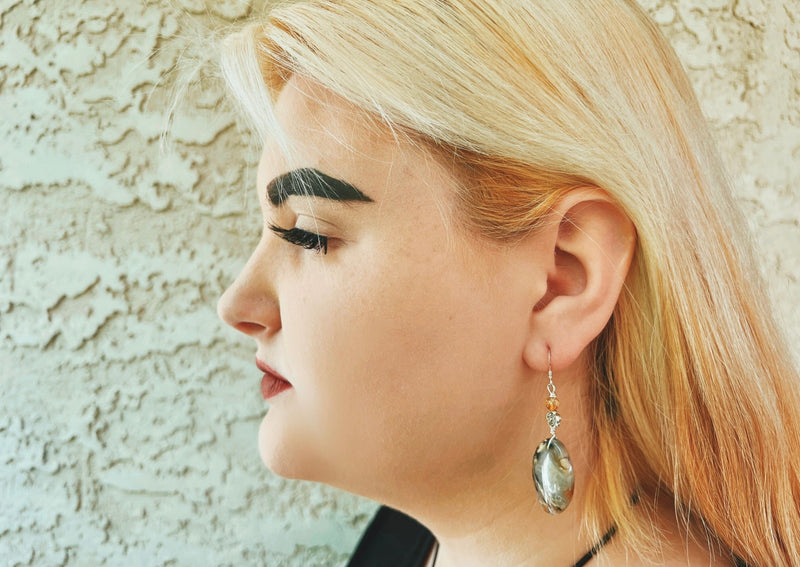 Moss Agate oval earrings with citrine and flower detail on sterling silver on model's ear. 