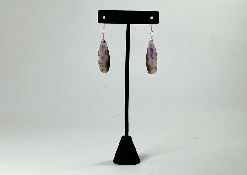chevron amethyst earrings hanging from t stand. 