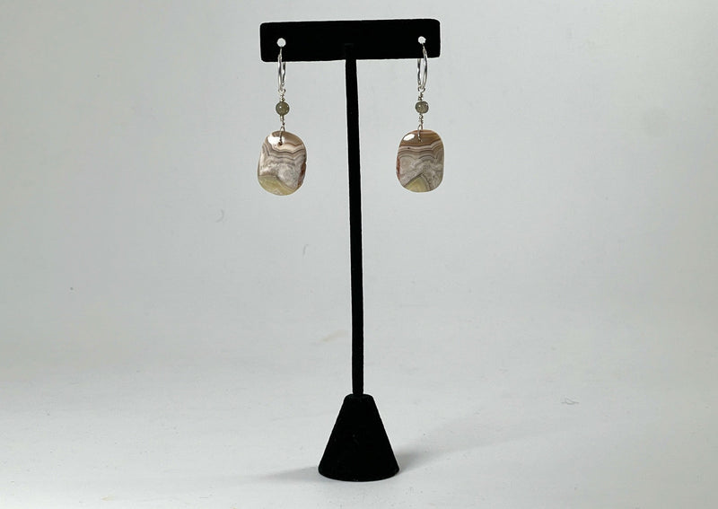 Crazy lace agate earrings hanging from t stand.