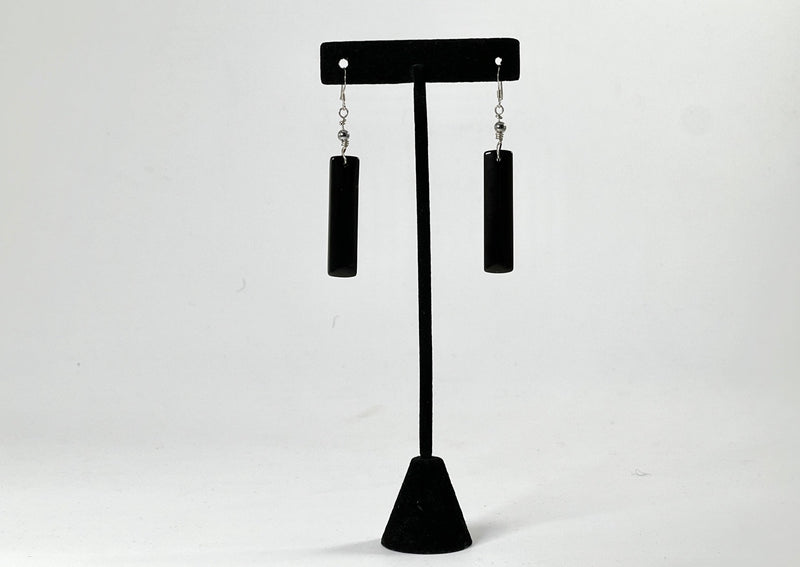 black rectangular obsidian earrings hanging from black t stand.