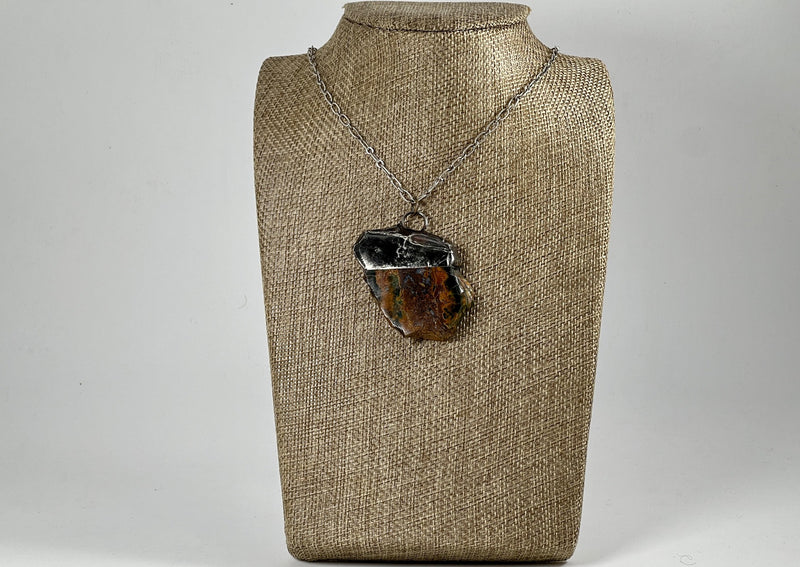 Petrified Wood Slab Pendant soldered and hanging on silver chain on linen bust display.