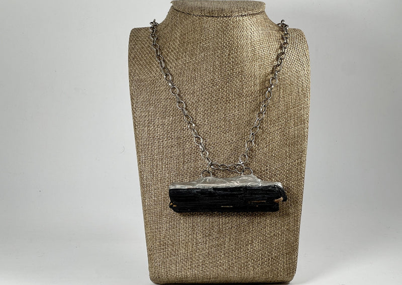 large black tourmaline on silver large link chain hanging around linen display bust.