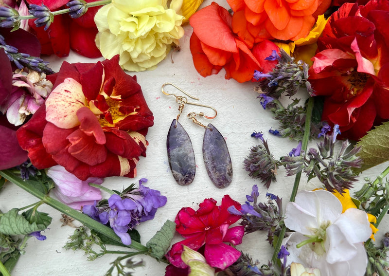 Chevron Amethyst teardrop earrings on table with flowers.