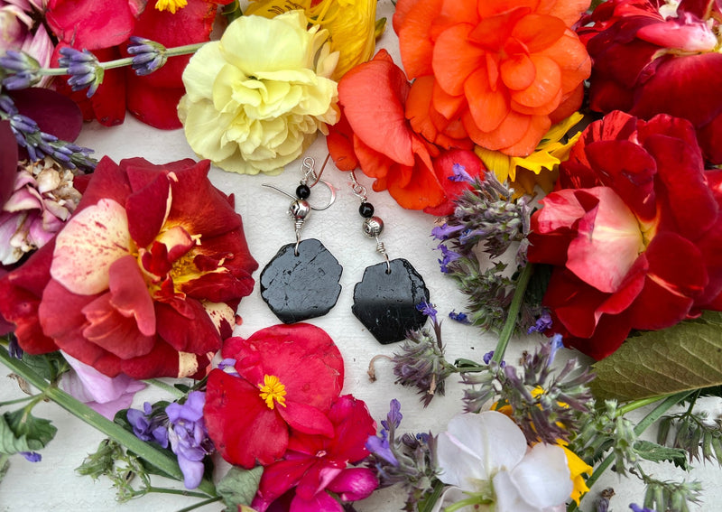 Black  Tourmaline earrings on table with flowers.