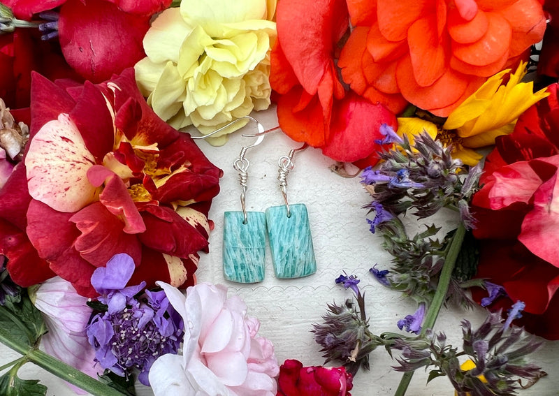 Russian Amazonite earrings on a table with flowers. 