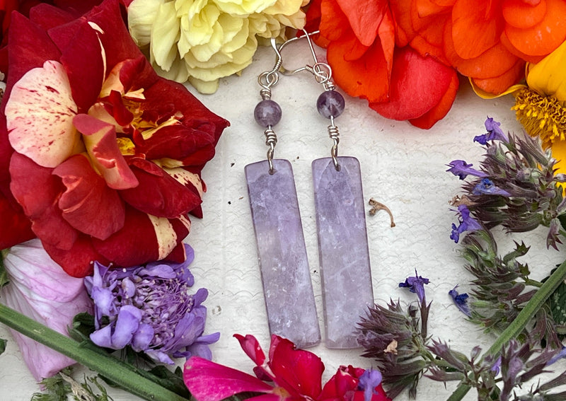 Amethyst Rectangular earrings on table with flowers.