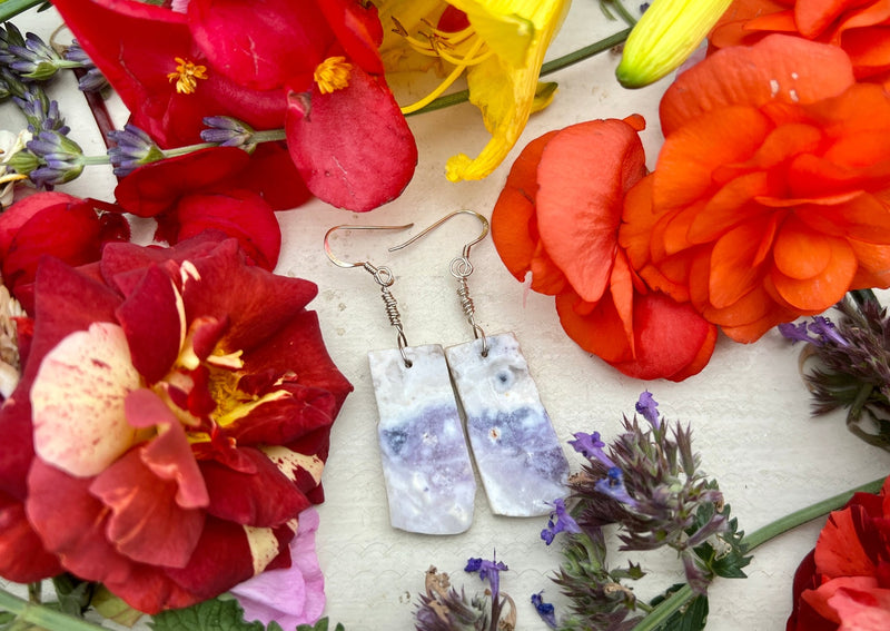 Mexican Opal Rough Slab earrings on table with flowers. 
