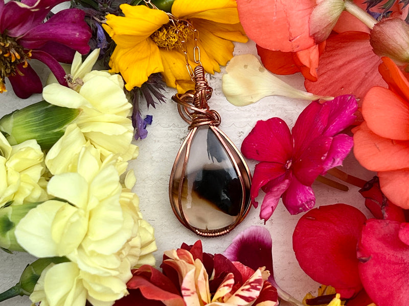 Montana Agate Pendant on table with flowers. 
